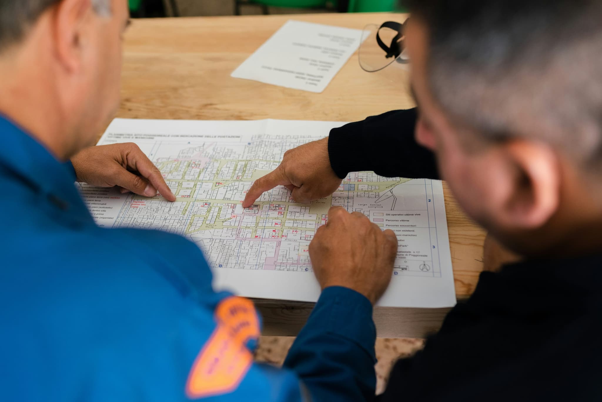 Two people over a printed plan, one walking the other through it point by point
